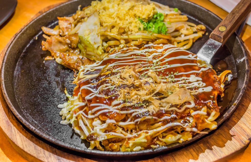 Closeup Cooking Okonomiyaki or japan pizza with hot iron frying pan.