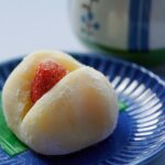 Close-up of a sweet strawberry mochi on a decorative blue plate.