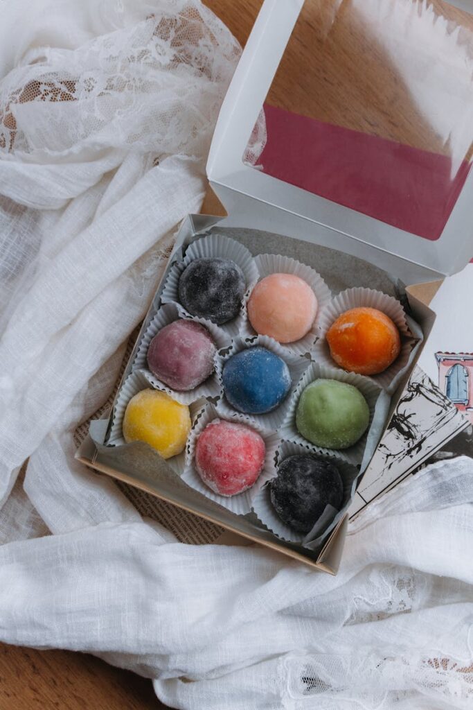 A vibrant assortment of mochi desserts in a bento box