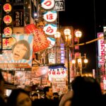 Explore the bustling nightlife of Osaka's Dotonbori street with vivid neon lights and bustling crowds.