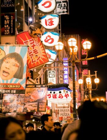 Explore the bustling nightlife of Osaka's Dotonbori street with vivid neon lights and bustling crowds.