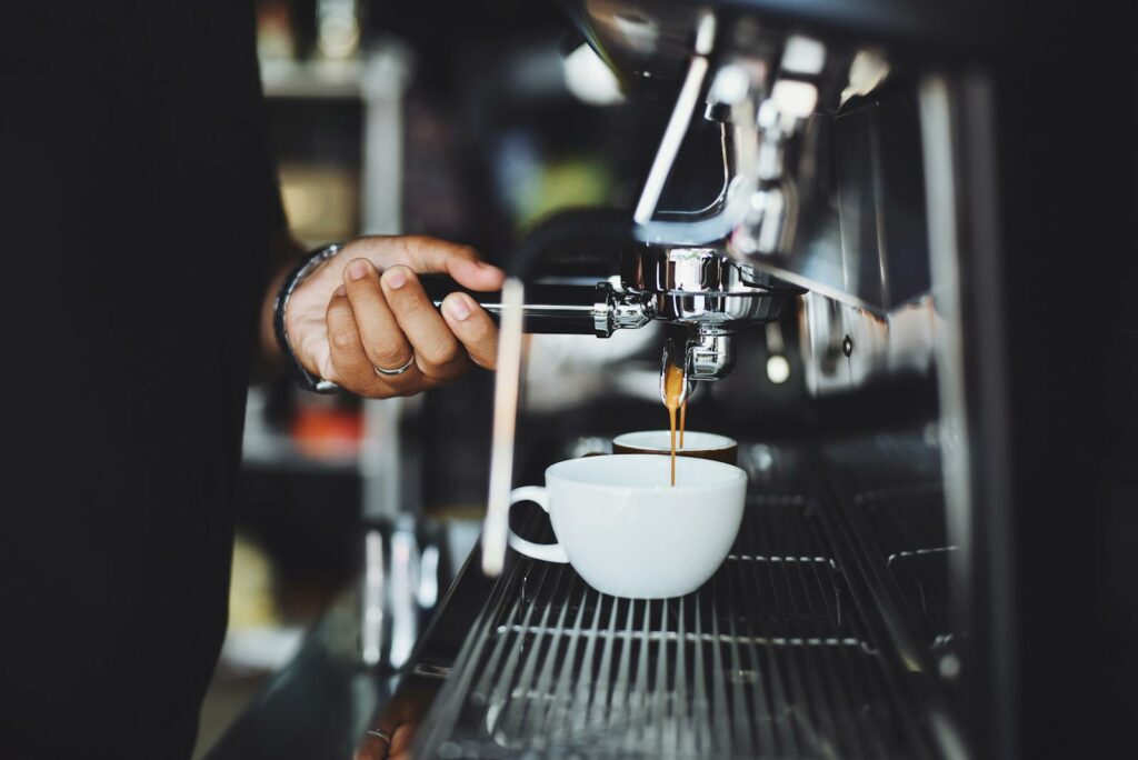 Close-up of a barista preparing espresso in a café using a machine