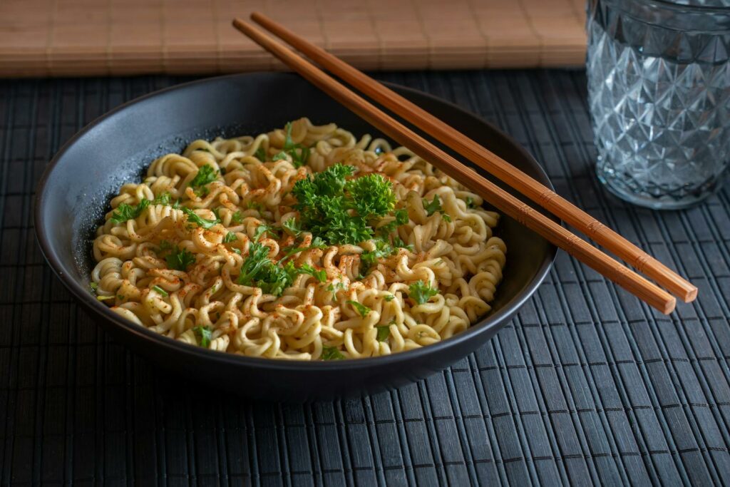 Delicious bowl of spicy instant noodles garnished with parsley, perfect for a quick meal.