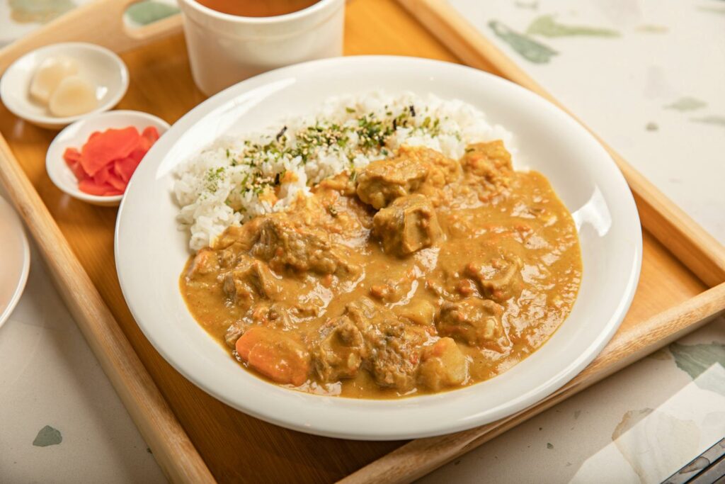 Japanese curry rice served with pickled vegetables and soup on a wooden tray, japanese diet