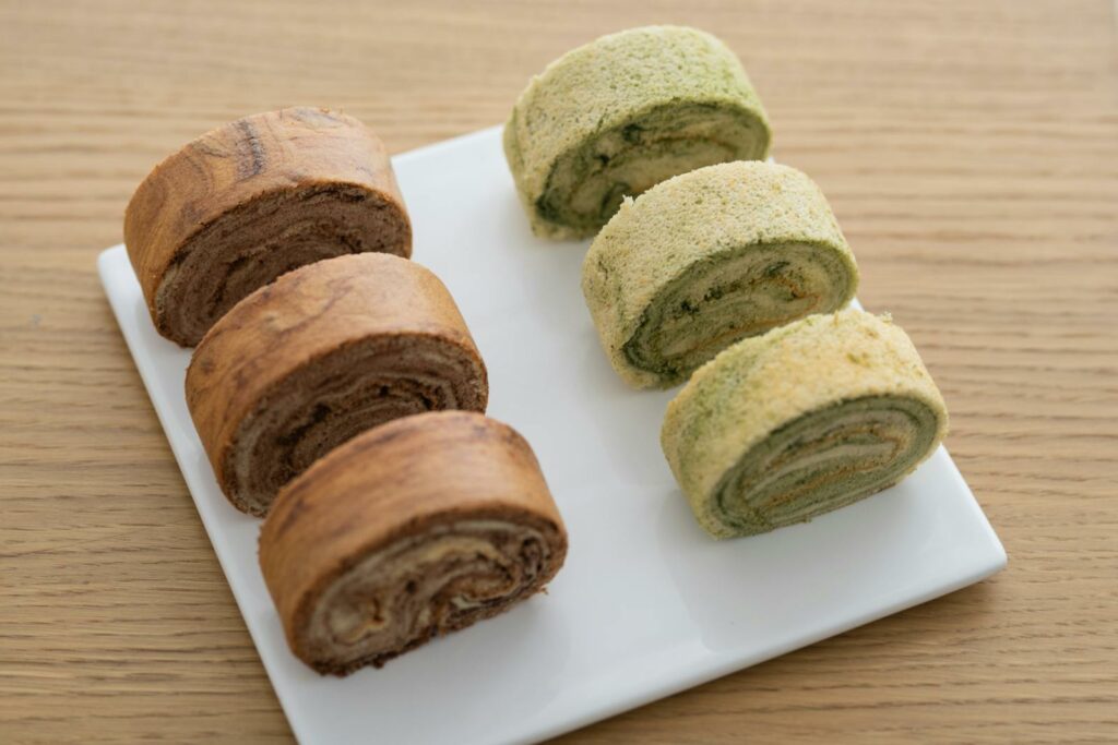 Close-up of chocolate and matcha cake roll slices on a plate, perfect for dessert lovers.