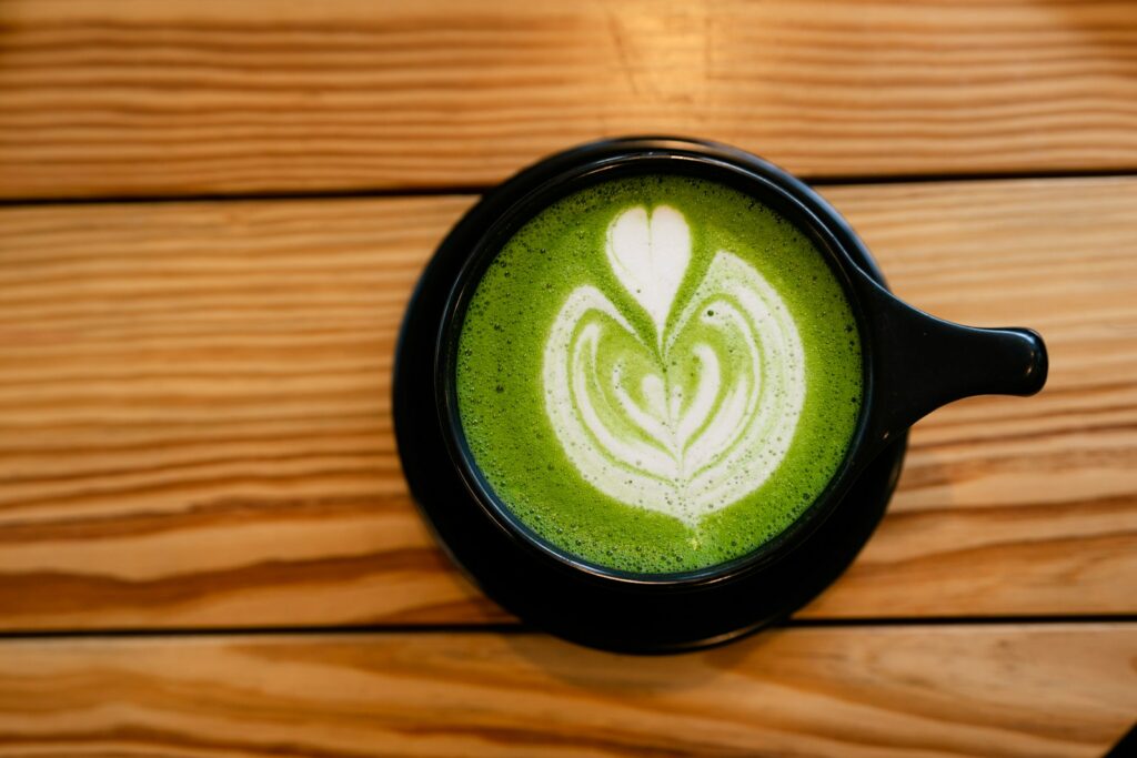 matcha latte drink on black ceramic mug, coffee alternative