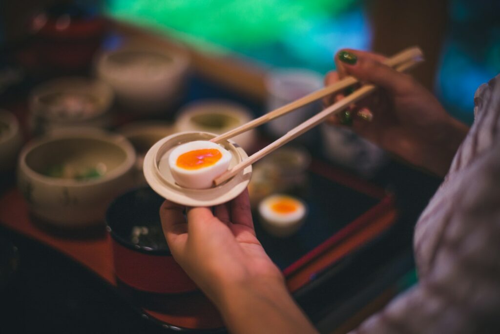 person holding chopsticks in plate, japanese foods, japanese diet