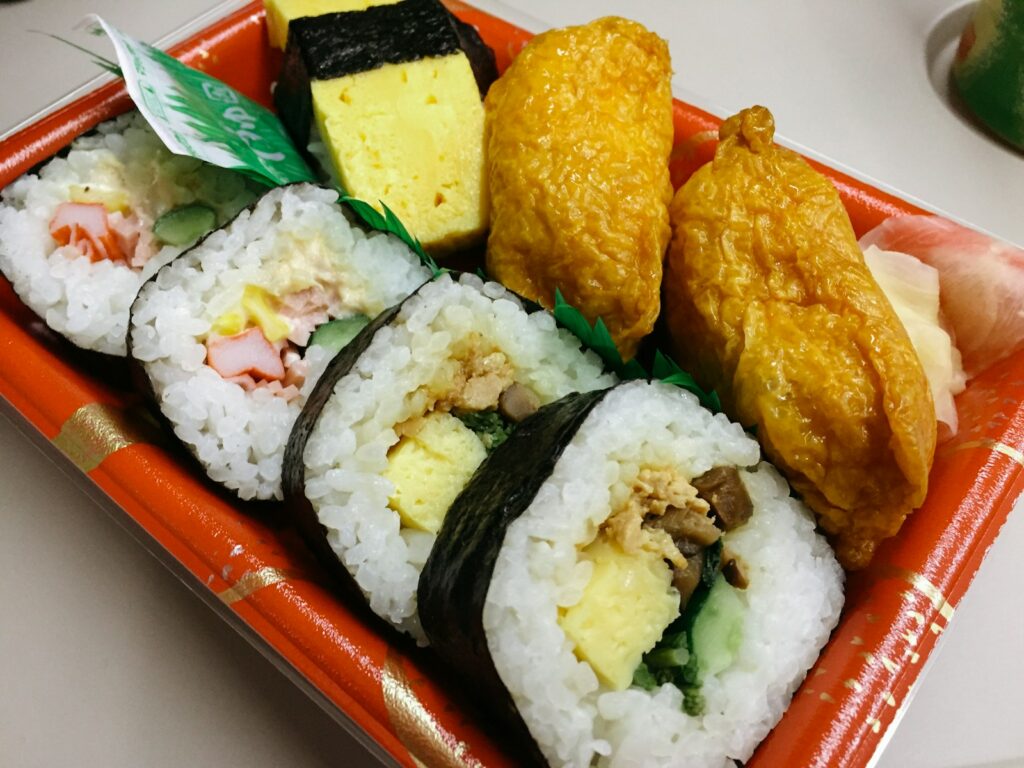 a plate of sushi with a variety of toppings, japanese bento box