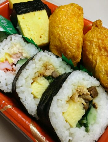 a plate of sushi with a variety of toppings, japanese bento box